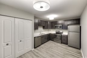large apartment kitchen with wood plan flooring and a pantry