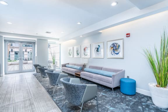 a living room with couches and chairs and a lobby area with paintings