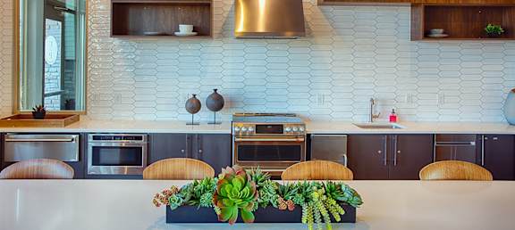 a kitchen with a white counter top and wooden cabinets