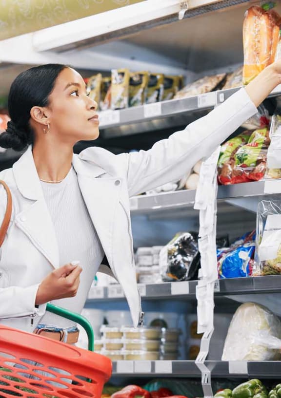 a woman shopping for food in a grocery store