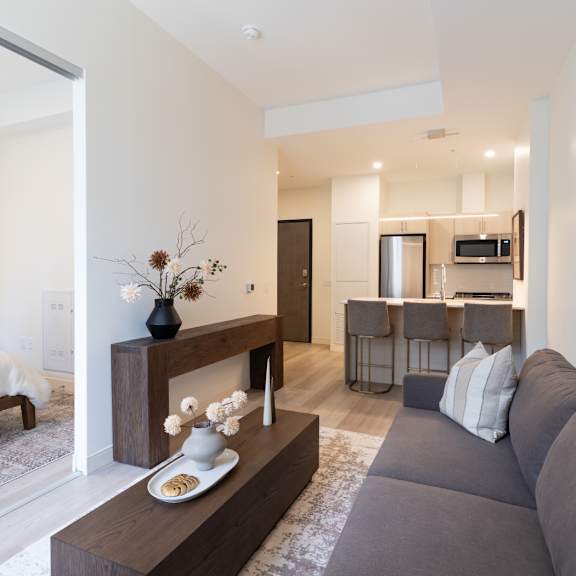 A modern living room with a grey sofa and a wooden coffee table.