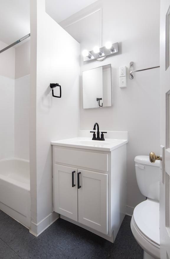 a white bathroom with a sink toilet and shower