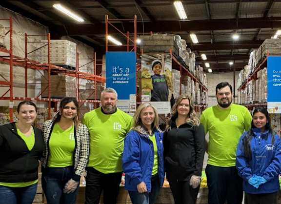 A group of people in a warehouse with signs that say "It's a Great Day for Inference".