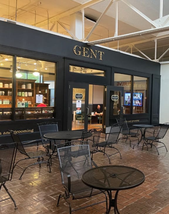 a courtyard with tables and chairs outside of a store