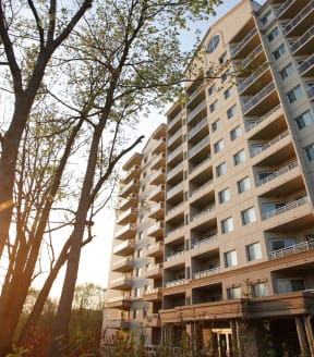 a large apartment building with balconies and trees in front of it