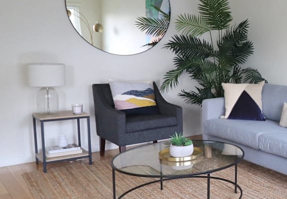 a living room with a couch and a table and a mirror