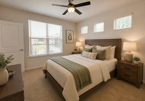 Staged bedroom with a large window in a 740-square-foot one-bedroom apartment at Auberge of Tyler.