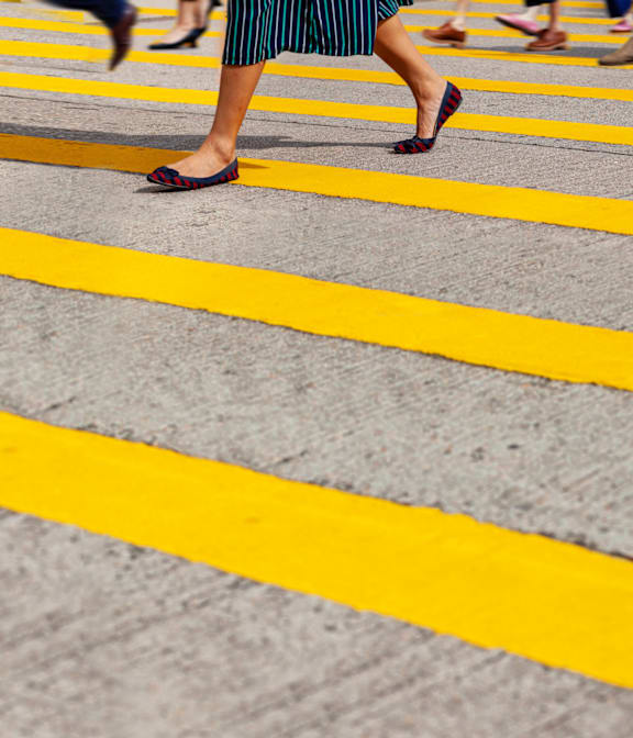 A person is walking across a yellow line on the road.