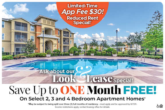 A large apartment complex with a pool and a sign offering a free month if you sign a lease.