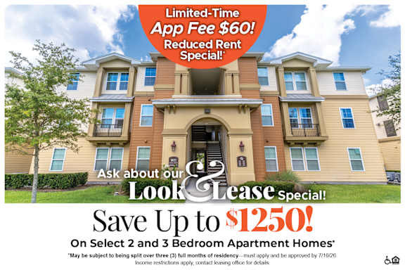 A large, multi-story apartment building with a sign offering a limited-time app fee discount and reduced rent special.