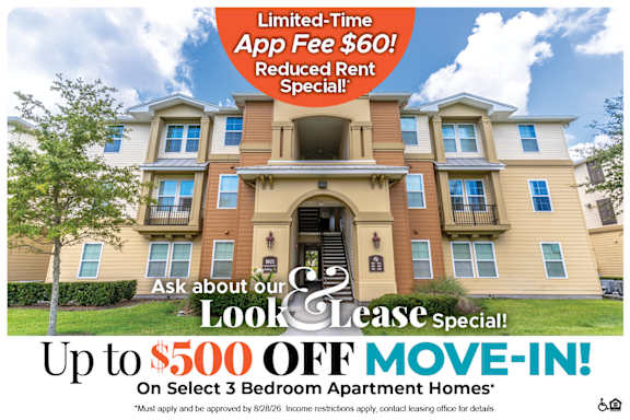 A large, multi-story apartment building with a sign offering a limited-time app fee discount and reduced rent special.