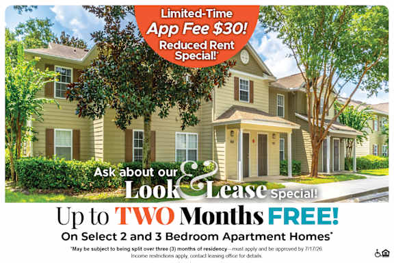 A house with a tree in front and a sign offering a free month on select homes.