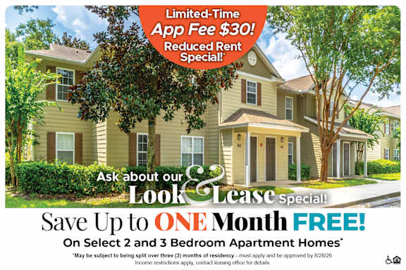 A house with a tree in front and a sign offering a free month on select homes.