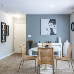 a dining room with a table and chairs in front of a window