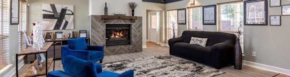 A living room with a fireplace and a blue chair.