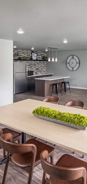 A modern dining room with a long table and chairs.