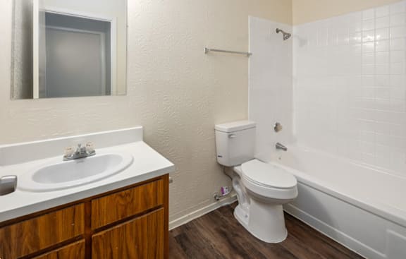 A white toilet sits next to a white sink in a bathroom.