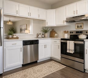 a kitchen with stainless steel appliances and white cabinets at Colony Townhomes, North Carolina, 27609