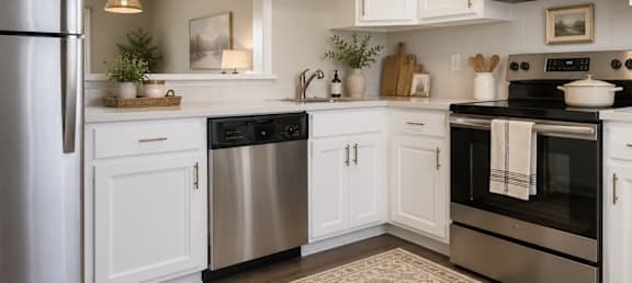 A kitchen with white cabinets and stainless steel appliances.