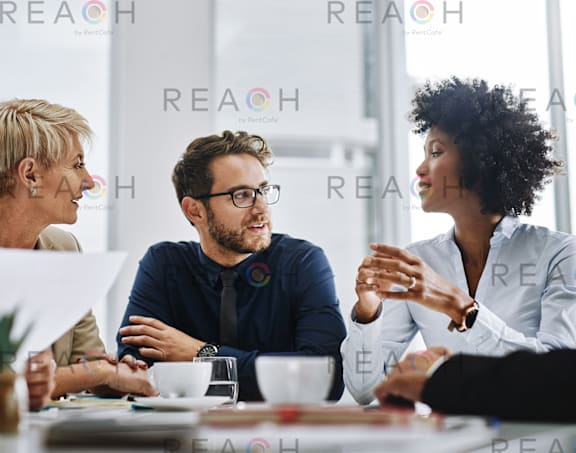 A group of people are having a meeting in a brightly lit room.