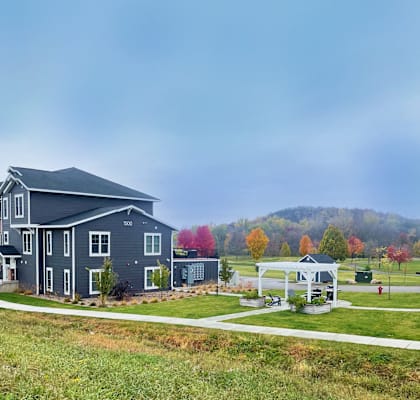 a blue house and a white gazebo on the side of a road