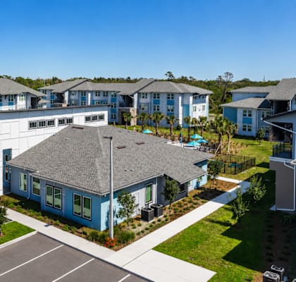 A row of houses with a parking lot in front.