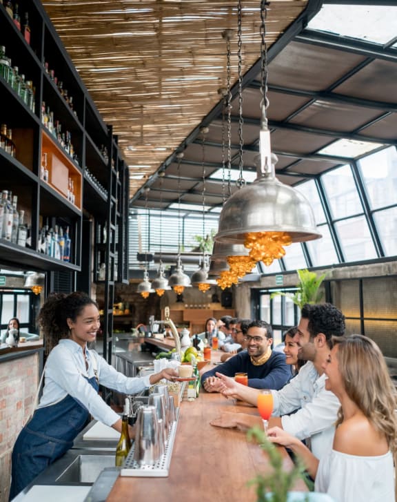a group of people sitting around a bar at a restaurant