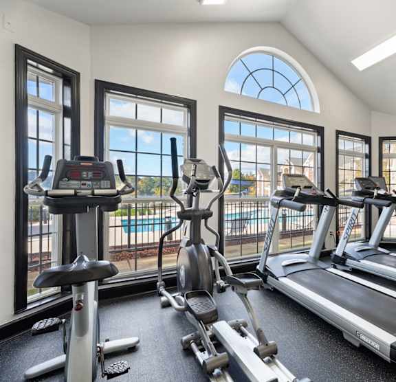 A gym with treadmills, elliptical machines, and stationary bikes. at Village on the Lake Apartments, Spring Lake, NC, 28390