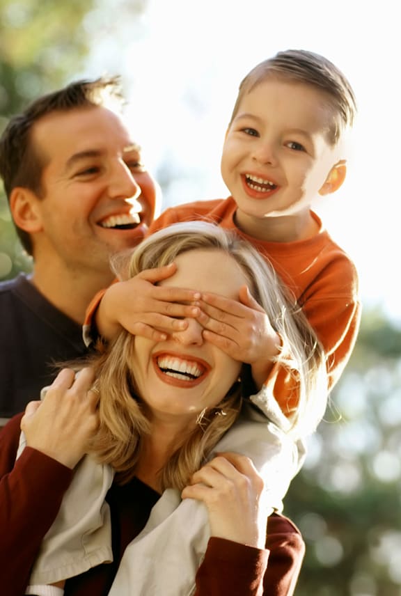 A woman is being playfully covered by a man and a child. at Meeker Commons Apartments , Greeley