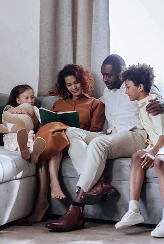 A family of four is sitting on a couch together. at Mountain Terrace Apartments , Westminster, 80031