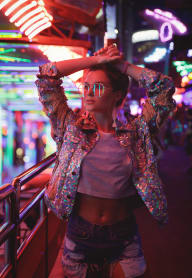 a woman standing in front of a neon sign at night