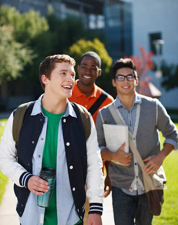Three students walking on a campus.