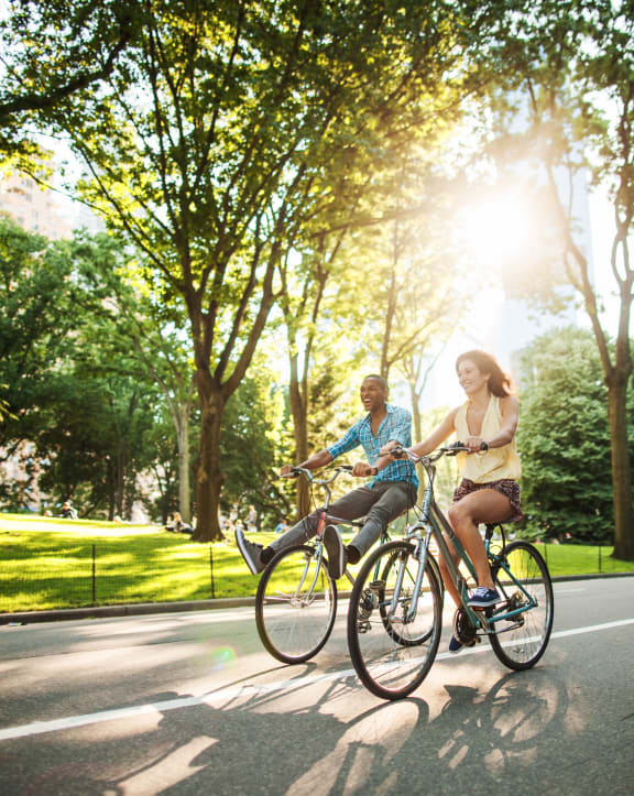 a man and a woman riding bikes down the street at Arbor Ridge, Greensboro