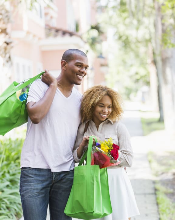 a man and woman walking down the street with shopping bags at Wendover River Oaks, Greensboro, NC, 27409