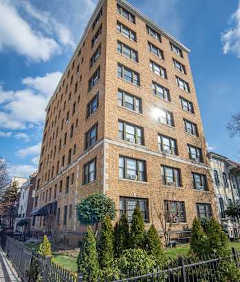a tall brick building with a fence in front of it