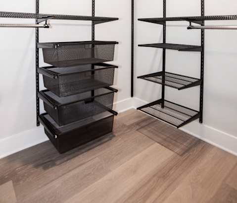 a storage room with black shelving and white walls and a wood floor