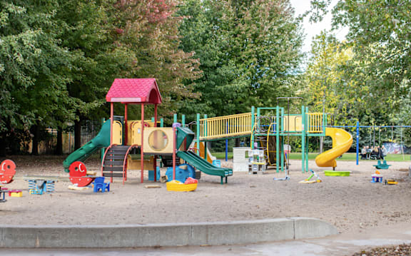 a playground at a park with toys on the sand