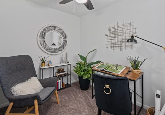 a living room with a chair and a desk
