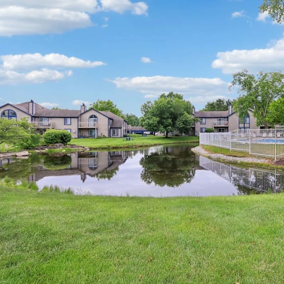 A pond in front of a row of houses.