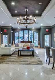 A spacious living room with a chandelier, couches, and a coffee table.
