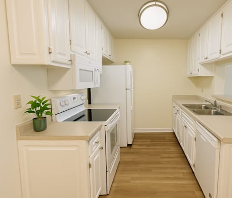 A kitchen with white cabinets and appliances.
