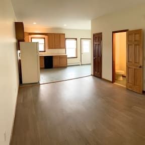 A spacious living room with wooden floors and furniture.