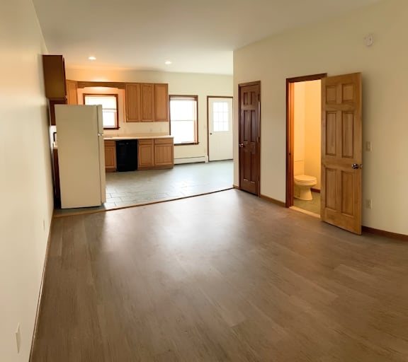 A spacious living room with wooden floors and furniture.