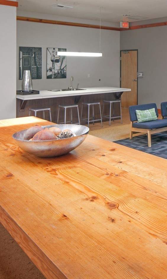 A wooden table with a fish bowl on it in the middle of a room.