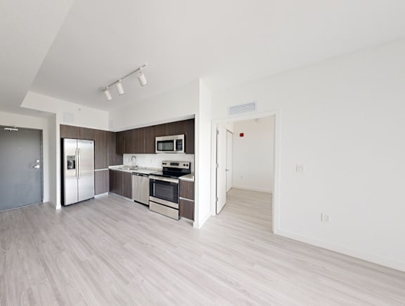 A kitchen with a refrigerator, oven, and microwave.