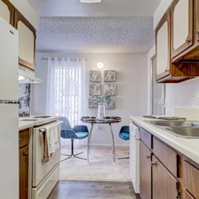 A kitchen with a white refrigerator and wooden cabinets.