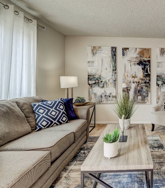 A living room with a couch, a coffee table, and a mirror.