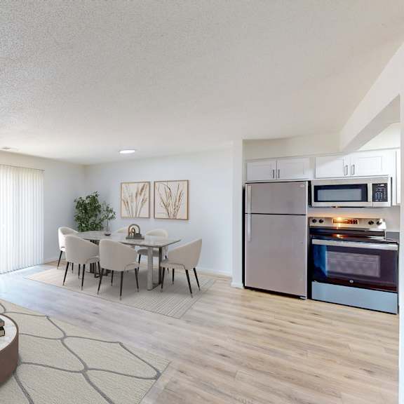 A modern living room with a grey sofa, a coffee table, and a kitchen in the background.