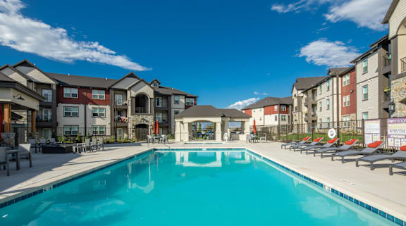A large swimming pool in front of apartment buildings.