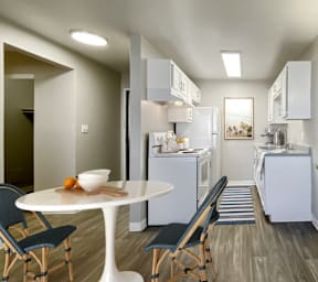 A modern kitchen with a dining table and chairs.